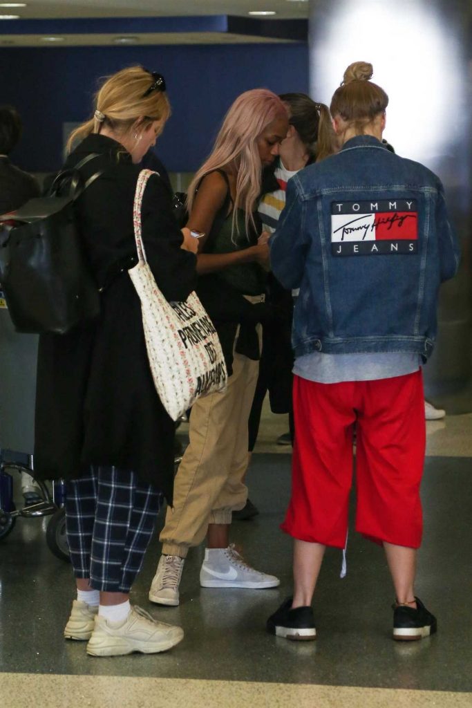 Suki Waterhouse in a Red Natasha Zinko Technical Nylon Joggers Was Seen at LAX Airport in Los Angeles 09/12/2018