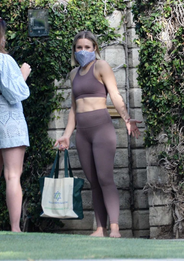 Kristen Bell in a Purple Workout Clothes Picks Up a Package from a