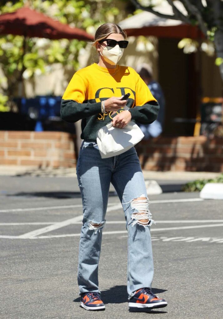 Sofia Richie in a Yellow and Black Sweater