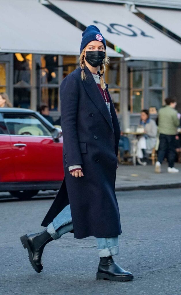 The 31-year-old Australian actress Margot Robbie in a black protective mask goes shopping in London.