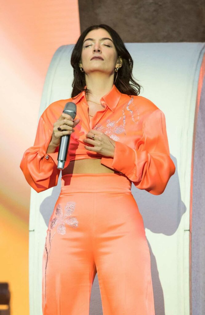 Lorde in an Orange Ensemble